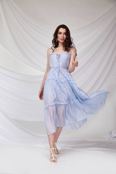Beautiful sexy woman wear light blue color dress summer collection cotton casual style tanned body brunette hair beautiful face makeup white background studio. - Φωτογραφία, εικόνα