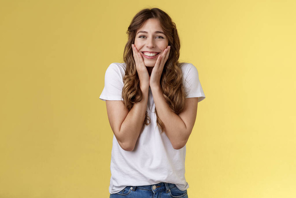 Cheerful happy upbeat young girl receive inredible opportunity study abroad student cheering celebrating stunning news touch cheeks blushing joy happiness smiling broadly yellow background - Photo, Image