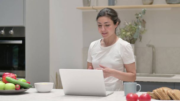 Young Indian Woman doing Video Call on Laptop in Kitchen - Photo, Image