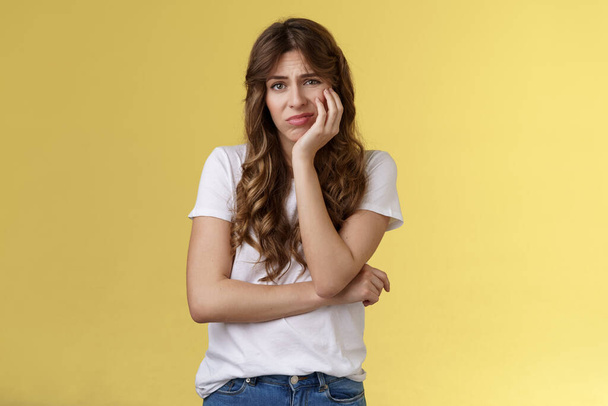 Upset distressed cute disappointed pretty girl feeling lonely regretting missed opportunity sighing sorrow sadness look camera apathetic indifferent lean face palm frowning jealous yellow background - Photo, Image