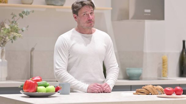 Middle Aged Man Shaking Head as No Sign while in Kitchen - Photo, Image