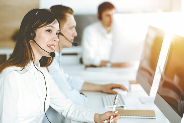 Asian woman working at customer service office. Business concept. Group of diverse operators at work in sunny call center. - Foto, Bild