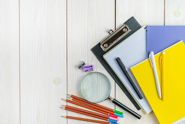 Pens, notebooks, pencils, sharpeners on a white background. Top view, copy space. - Foto, afbeelding