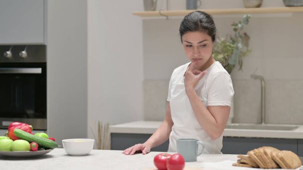 Jeune femme indienne se sentant inquiet tandis que debout dans la cuisine - Photo, image