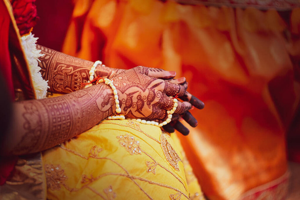The hands of an Indian female from the side covered with tattoos and bracelets - Photo, Image