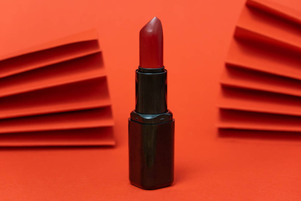 moda flatlay foto de cosméticos productos de belleza lápiz labial sobre fondo rojo - Foto, imagen