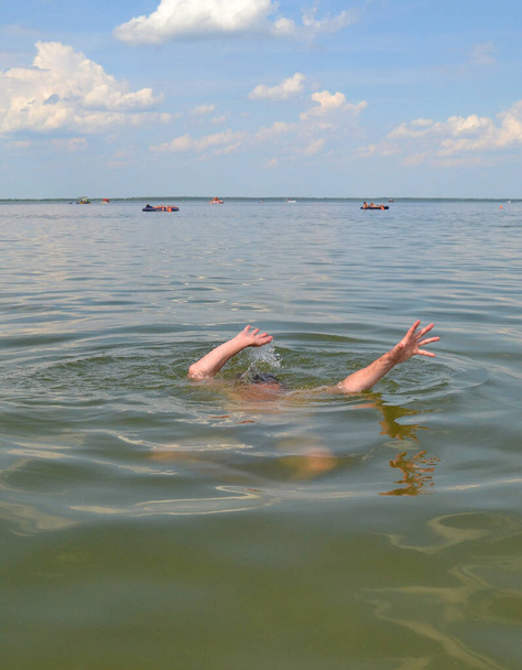 Ruce topícího se muže nad vodou, který potřebuje pomoc. - Fotografie, Obrázek