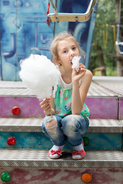 Young girl relishing a stick of candy floss - Fotó, kép