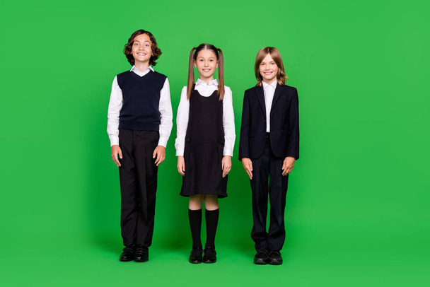Full length body size view of attractive cheery kids classmates new grade isolated over bright green color background - Zdjęcie, obraz