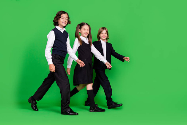 Full size profile photo of nice little girl boys go wear school uniform isolated on green background - Foto, immagini