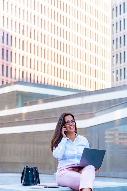 Caucasian business woman with laptop in the city - Photo, Image