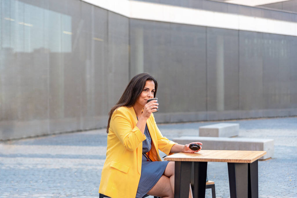 Біла бізнес-леді відпочиває і п'є каву зовні
 - Фото, зображення