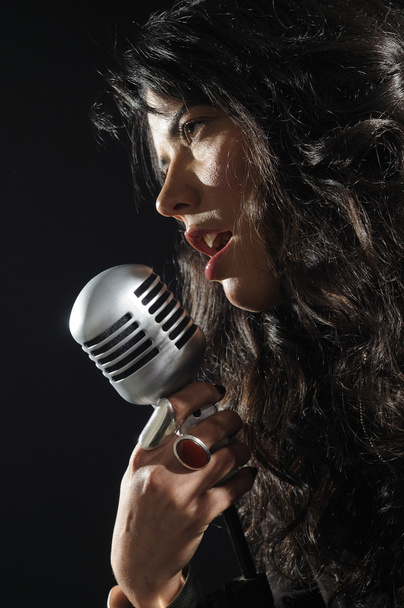 Brunette beauty singing on retro mic - 写真・画像