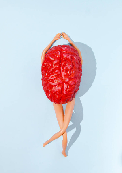 Un cerebro humano rojo con piernas y brazos sobre fondo azul pastel. Pon tu mente a gusto o a tiempo para el concepto creativo del ocio o el diseño artístico de la libertad humana. - Foto, imagen