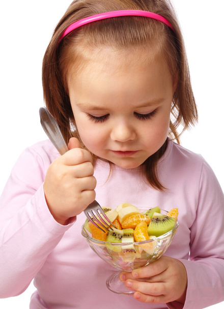 Little girl eats fruit salad - Fotó, kép
