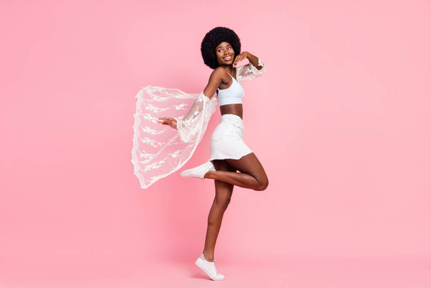 Full body profile side photo of happy nice young afro american lady look copyspace walk isolated on pink color background - Фото, зображення