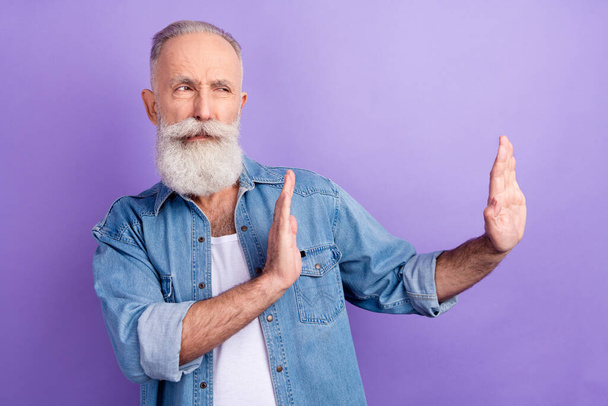 Photo of charming confident mature man dressed denim outfit showing no looking empty space isolated purple color background - Фото, зображення