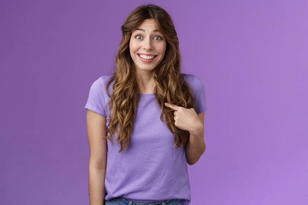 Who me awesome. Surprised silly tender delighted happy girl smiling impressed amazed pointing herself raise eyebrows astonished not expect hear own name stand purple background winning event - Photo, Image