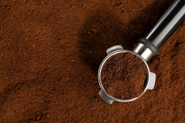 Coffee background. Coffee automatic from machine with ground coffee  on coffee background. Closeup.  - Фото, зображення