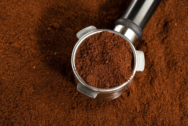 Coffee background. Coffee automatic from machine with ground coffee  on coffee background. Closeup.  - Фото, зображення
