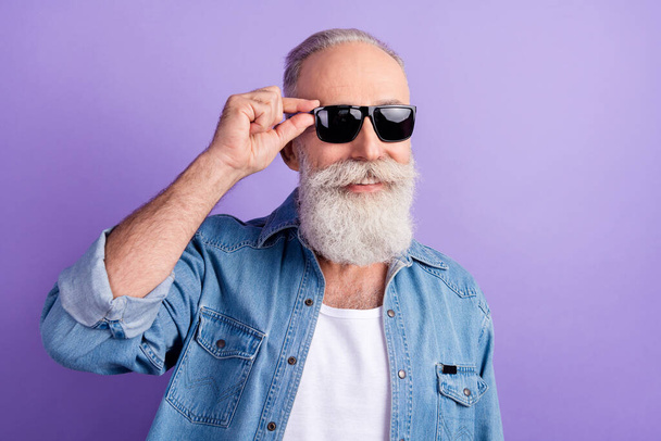 Photo of handsome aged man happy positive smile confident hand touch sunglass isolated over purple color background - Fotó, kép