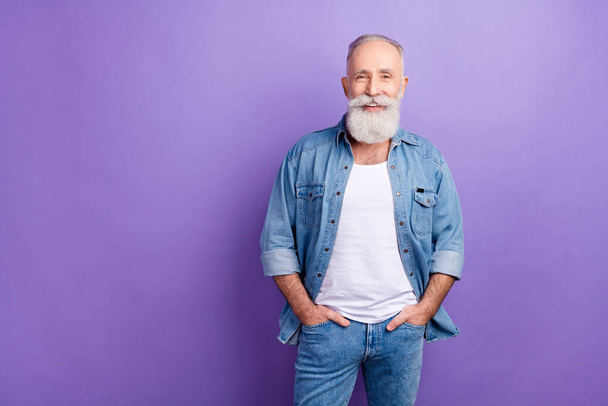 Photo of handsome senior man happy positive smile confident hands in pocket isolated over violet color background - Zdjęcie, obraz