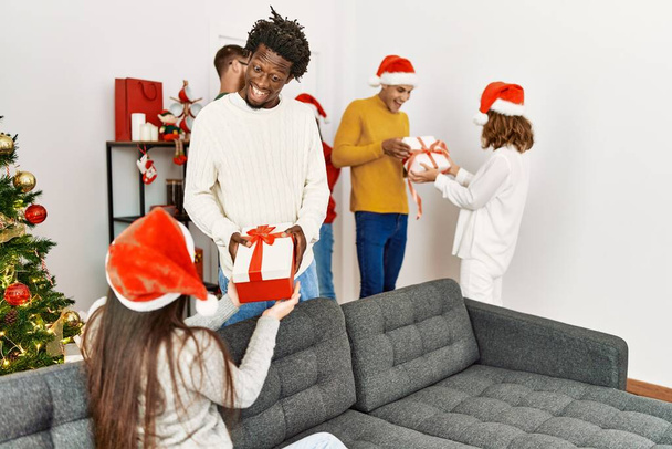 Gruppo di giovani che fanno regali di Natale a casa. - Foto, immagini