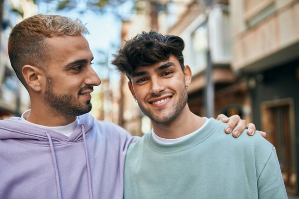 Jeune couple gay souriant heureux et câlin à la ville. - Photo, image