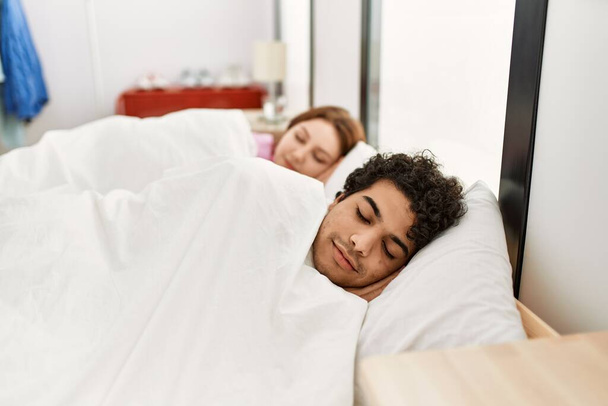 Молодая пара улыбается счастливый сон на кровати в спальне. - Фото, изображение