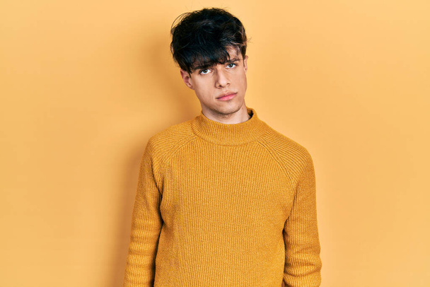 Handsome hipster young man wearing casual yellow sweater depressed and worry for distress, crying angry and afraid. sad expression.  - 写真・画像