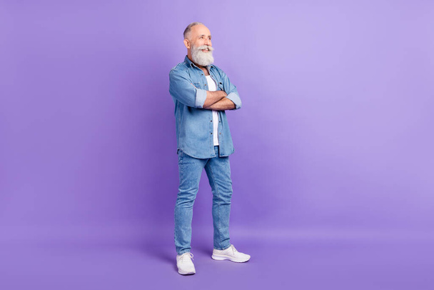 Full length profile side photo of aged man happy positive smile crossed hands look empty space isolated over violet color background - Fotoğraf, Görsel