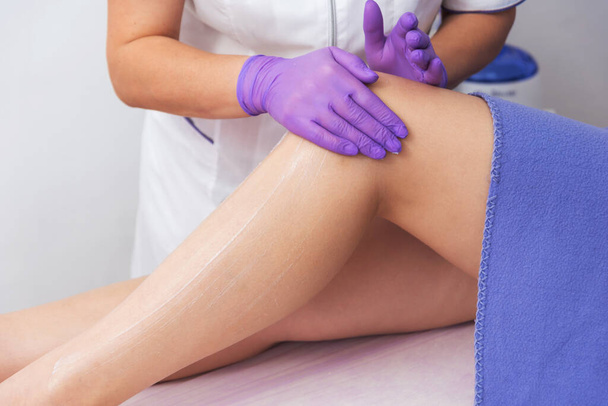 Kosmetische Prozedur Anwendung Creme auf die Beine Enthaarung Epilation Reiben Creme Hautweichmachung - Foto, Bild