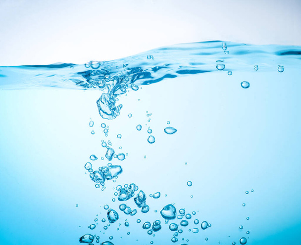 A víz áramlása fröccsenést és kék hullámokat hoz létre a víz alatt, és a buborékok természetesen a felszínre áramlanak. fénymásolási hellyel - Fotó, kép