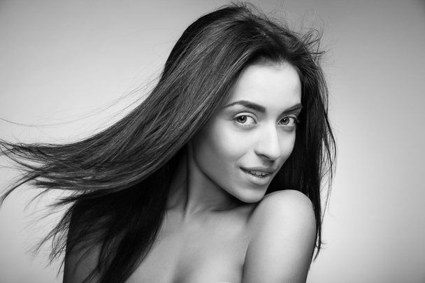 Attractive smiling woman with long hair on grey - Foto, immagini