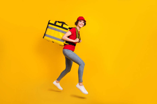 Full size profile photo of nice optimistic brown hair lady jump with bag wear t-shirt cap isolated on yellow background - Valokuva, kuva