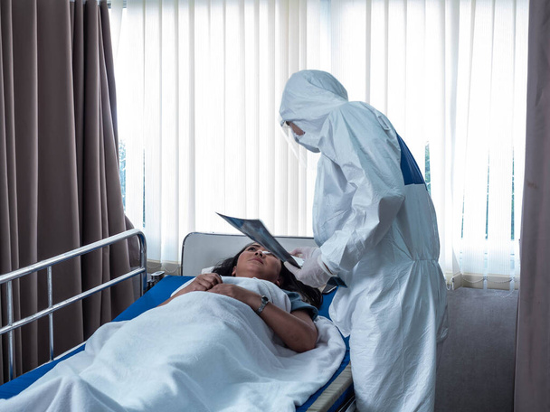 Hastane kliniği acil servis doktoru erkek bilim adamı beyaz üniforma giyiyor hasta yataklı iş kadınları sağlık aşısı covid-19 Corona virüsü tıbbi koruma - Fotoğraf, Görsel