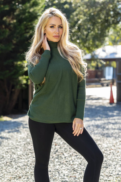 A gorgeous blonde model poses outdoors in her fall clothes - Fotó, kép