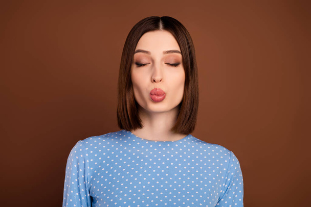 Photo of flirty bob hairdo young lady blow kiss wear blue blouse isolated on brown color background - Fotografie, Obrázek