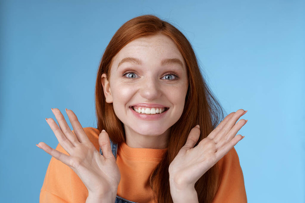 Happy rejoicing emotional young smiling redhead girl blue eyes getting exciting news grinning cheering happily raise hands thrilled wide eyes surprised accepted famous university, blue background - Foto, immagini