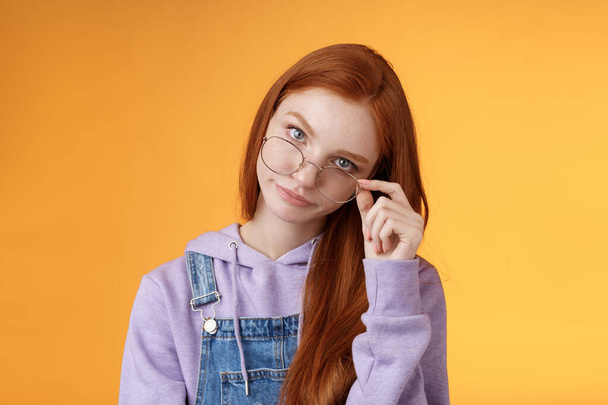 You gotta be kidding me. Annoyed redhead smart irritated elder sister look from under forehead take off glasses roll eyelids smirking disturbed pissed stupid jokes, standing orange background - Foto, immagini
