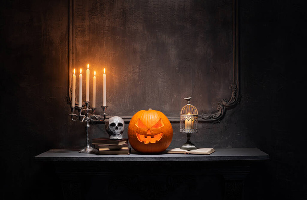 Scary laughing pumpkin and old skull on ancient gothic fireplace. Halloween, witchcraft and magic. - Фото, зображення