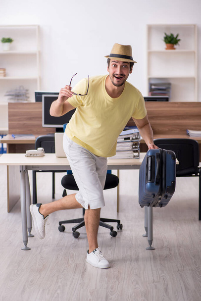 Young male employee preparing for trip at workplace - Photo, Image