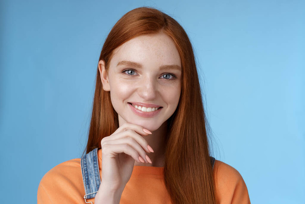 Curieux intelligent créatif jeune rousse féminine yeux bleus ont une idée parfaite comment passer des vacances d'été souriant regard joyeux intrigué toucher réfléchi menton réfléchissant choix, debout fond bleu - Photo, image