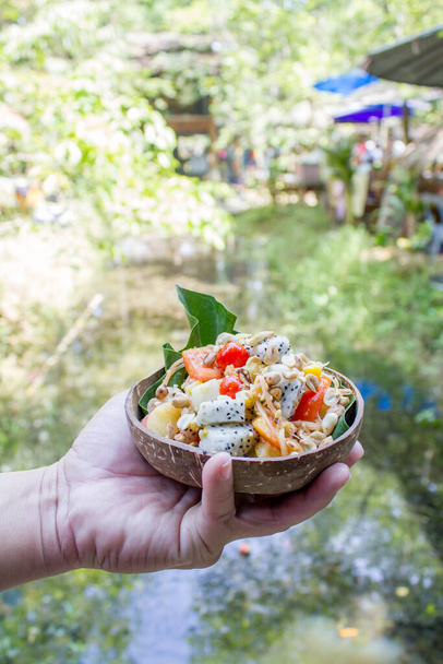 Тайский салат из свежих фруктов в кокосовой миске - Фото, изображение