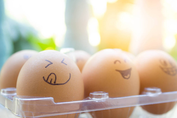 смешные яйца с нарисованным лицом в коробке - Фото, изображение