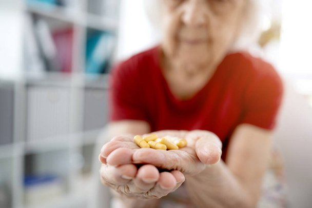 Senior woman taking medicine - Фото, изображение