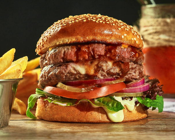 Double hamburger with two patties, pickles, tomatoes, onion, greens - 写真・画像