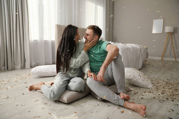 Happy young couple resting after fun pillow fight in bedroom - Φωτογραφία, εικόνα