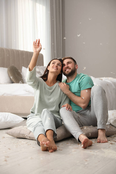 Happy young couple resting after fun pillow fight in bedroom - Photo, Image