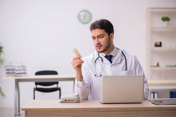 Mladý lékař drží pilulky na klinice - Fotografie, Obrázek